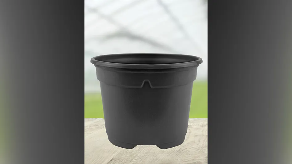 A brown plant pot sits in a greenhouse.